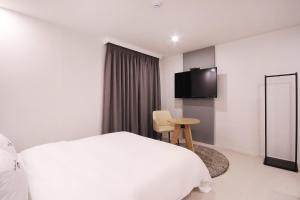 浦项XYM Hotel Mundeok的酒店客房,配有床和电视