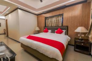 古瓦哈提Airport Guest House Guwahati的一间卧室配有一张带红色枕头的大床