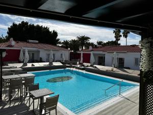 马斯帕洛马斯Paradise Resort - FKK Swinger & Nudist Couples Only的一个带椅子和桌子的大型游泳池