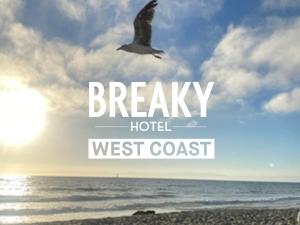 浦添BREAKY HOTEL west coast的一只鸟飞过海滩,在西海岸边的鸟儿们说着破烂的