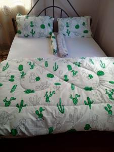 阿鲁沙Arusha homestay的一张带绿色植物的白色棉被的床
