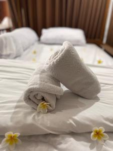 KlungkungKelingking Hostel的床上的毛巾,上面有鲜花
