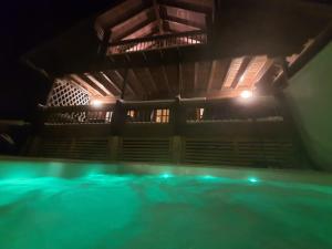 KoroVilla Nurminiemi的夜间带绿灯的室内游泳池