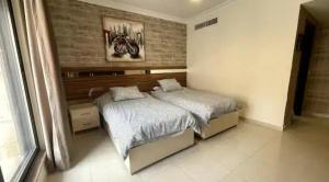安曼Luxurious cozy apartment的一间卧室设有一张床和砖墙