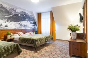 扎科帕内Pensjonat Maria 5的酒店客房设有两张床,墙上挂有绘画作品