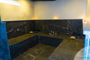 马拉喀什Villa Boutique Amani的一间带水槽和黑色大理石墙的浴室