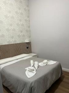 罗马装饰艺术酒店的床上有毛巾和盘子的床