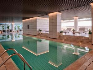 科威特Grand Hyatt Kuwait Residences的大楼内一个带桌椅的游泳池