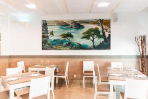 费雷列斯罗阿尔公寓酒店的一间设有桌子的用餐室和墙上的绘画