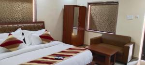 布什格尔SK Pushkar Resort的配有一张床和一把椅子的酒店客房