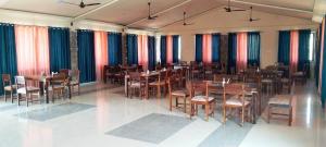 布什格尔SK Pushkar Resort的餐厅设有木桌、椅子和色彩缤纷的窗帘
