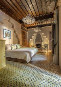 马拉喀什马拉喀什苏丹娜世界小型豪华酒店的一间卧室配有一张大床和一个吊灯。