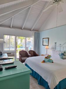 格雷斯湾西博恩海滩酒店 的卧室配有一张白色大床和一张书桌