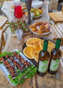 ShuakheviGuest House Okropilauri的一张桌子,上面放着盘子和两瓶葡萄酒