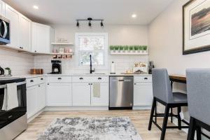 南本德South Bend Serenity: Freshly Renovated 3BR 2mi ND的厨房配有白色橱柜和桌椅