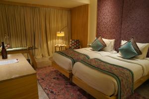 斋浦尔Hotel Royal Orchid Jaipur, Tonk Road的酒店客房设有一张大床和一张书桌。