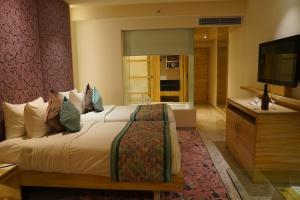 斋浦尔Hotel Royal Orchid Jaipur, Tonk Road的酒店客房,配有床和电视