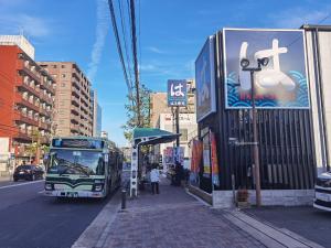 京都秋桜館Cosmos的停在城市街道上的一个公共汽车站的公共汽车