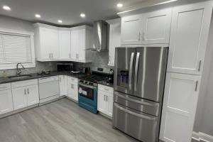 费城The Hidden Gem的厨房配有白色橱柜和不锈钢用具