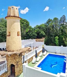科尔多瓦Hostal El Brillante - Alojamientos El Duque的一座游泳池和一座灯塔,位于一座建筑的顶部