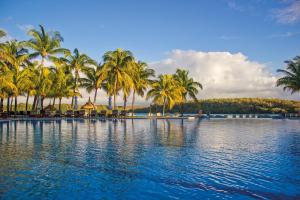蓝海湾Shandrani Beachcomber Resort & Spa的一座棕榈树和水的大型游泳池