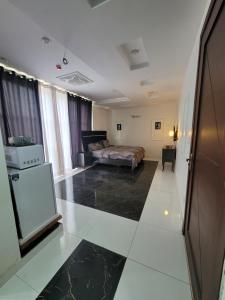 拉合尔Ultra muse Studio Apartment的配有床和冰箱的酒店客房