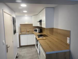 圣艾格夫Appartement Sol y Mar的厨房配有白色橱柜和木制台面