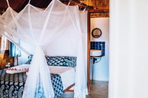 维兰库卢什Baobab Beach Vilanculos的一间卧室配有一张带天蓬的床