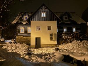 捷克布杰约维采Boutique Cottage Tkalcovna的夜晚雪中的房子