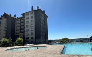 比亚里卡Departamento Costanera Villarrica的大楼前的游泳池