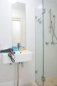 悉尼Charming house in Leichhardt的一间带水槽和玻璃淋浴的浴室