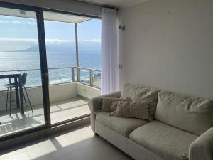 La ChimbaDepartamento Antofagasta. Playa privada的带沙发的客厅,享有海景