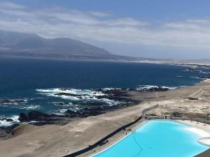 La ChimbaDepartamento Antofagasta. Playa privada的享有海滩和游泳池的空中景致