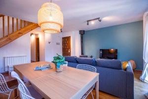 皮德拉菲塔德雅卡Las Vistas de Peña Blanca的客厅配有桌子和蓝色沙发