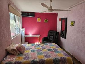 韦拉克鲁斯CONFORT的一间卧室配有一张床和粉红色的墙壁