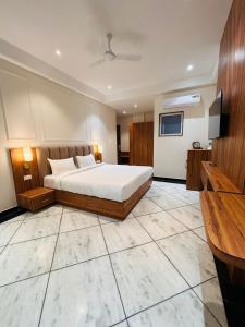 斋浦尔Hotel Saaj Mansion的一间大卧室,配有一张床和一台电视