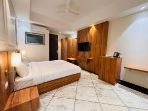 斋浦尔Hotel Saaj Mansion的一间酒店客房,配有一张床和一台电视