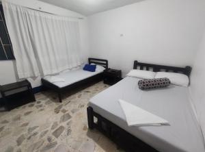 梅尔加Hotel Marqués de San Luis的一间卧室设有两张单人床和一个窗户。