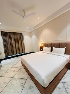 斋浦尔Hotel Saaj Mansion的一间卧室设有一张大床和一个窗户。