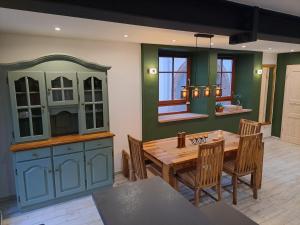 巴特贝格匝本Gästehaus Merlin的一间带木桌的厨房和一间餐厅