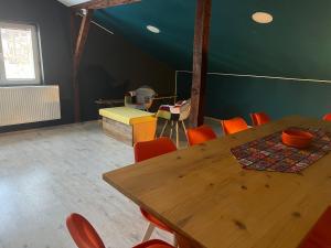 斯科普里Blue Orange Hostel的配有木桌和橙色椅子的用餐室