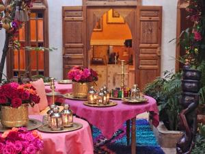 马拉喀什纳恩多旅馆的一间设有两张桌子的房间,配有蜡烛和鲜花