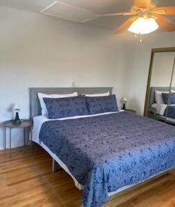 费城Nolibs Green Haven Sleeps 12的一间卧室配有一张蓝色的床和吊扇