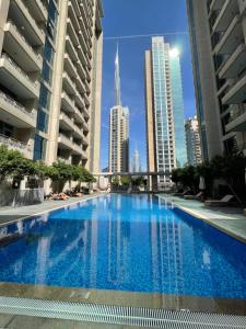 迪拜Cosy & Spacious 2 BR l Magical Boulevard View l by Burj & Dubai Mall I Pool I Gym I Family friendly的一座位于城市的游泳池,有高大的建筑