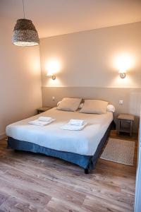 弗代纳La Blanchère, vue golf的一间卧室配有一张床,上面有两条毛巾