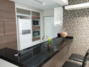 伊塔佩马Ótimo Apartamento vista mar a 70 metros的厨房配有黑色台面和水槽