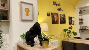 CroixLa Tropicale de Croix - Chambre d'Hôtes的一张桌子上挂着植物的黑猫雕像
