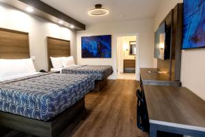 休斯顿Palace Inn Blue Edgebrook的酒店客房设有两张床和一台平面电视。