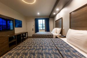 休斯顿Palace Inn Blue Edgebrook的酒店客房设有两张床和一台平面电视。