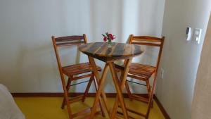 普拉杜Recanto Berlin的一张带两把椅子的木桌和一个花瓶